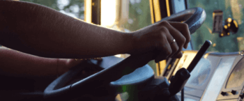 close up of truck drivers hands on steering wheel