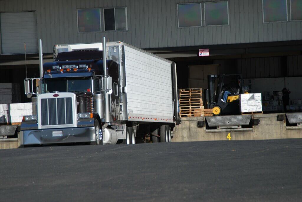 semi truck backed up to a dock waiting on freight