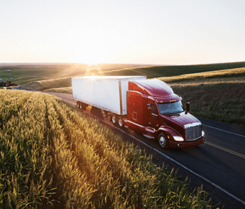 Truck driving with fields beside.
