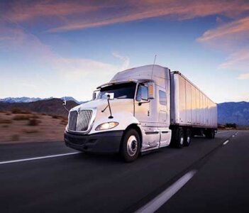 Truck on the highway at sunrise.