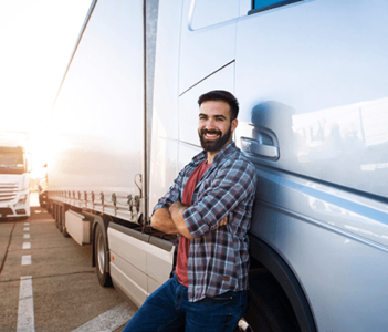 Driver leaning against a truck.