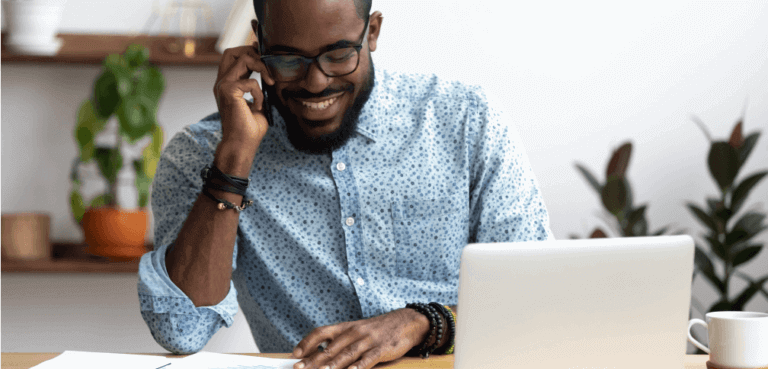 Broker using a cell phone while sitting at a desk.