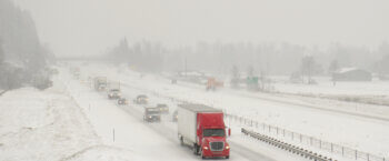 Semi truck driving on the highway in snowy conditions