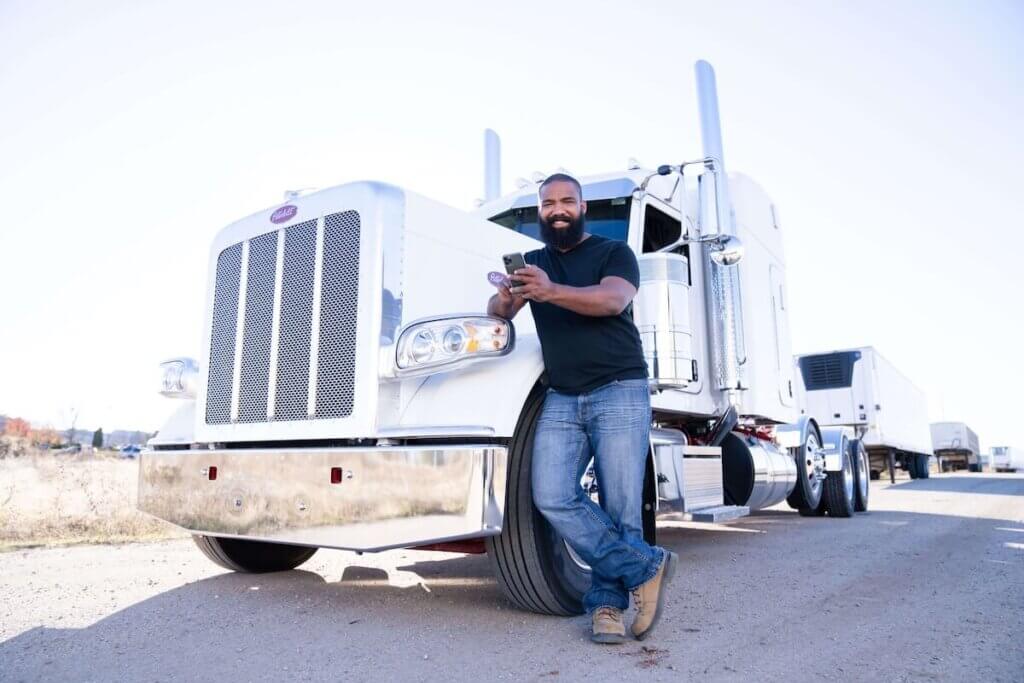 man in front of truck with phone