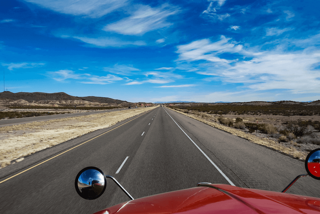 View of the highway ahead under a blue sky.