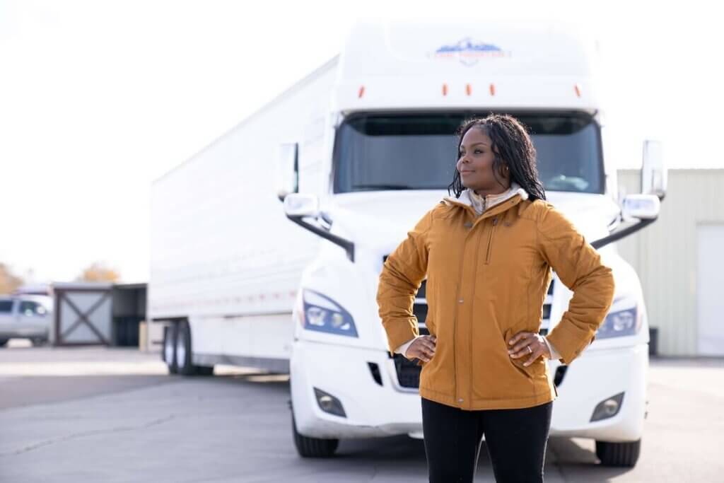 woman truck driver standing in front of a semi